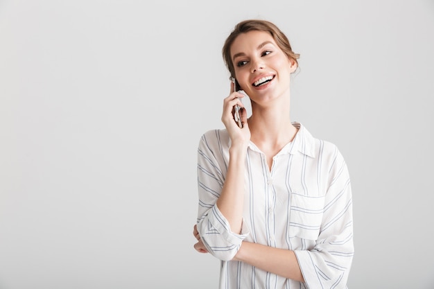 alegre linda mulher rindo e falando no celular isolado sobre fundo branco