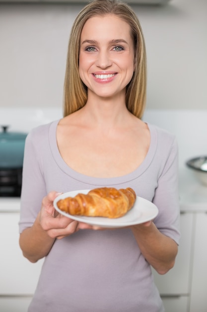 Alegre lindo modelo segurando prato com croissant