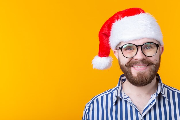 Alegre louco fofo jovem hippie masculino com chapéu de papai noel vermelho posando