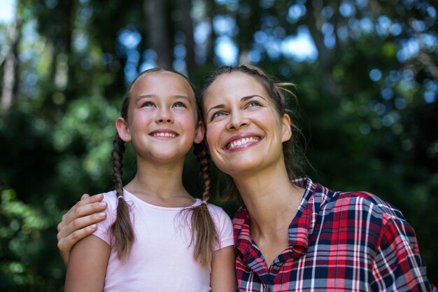 Foto alegre madre con hija mirando hacia arriba