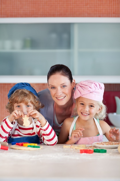 Foto alegre madre hornear con sus hijos