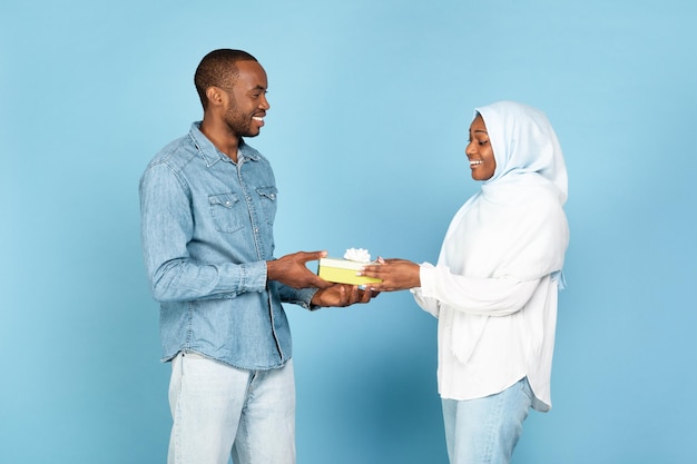 Alegre Marido Musulmán Negro Dando Presente Felicitando Esposa Sobre Fondo Azul