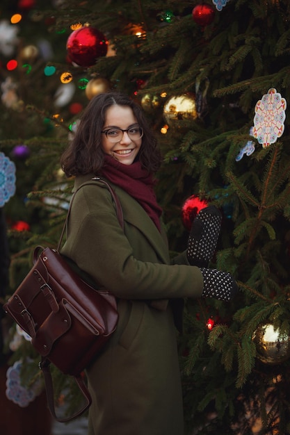 Alegre menina feliz aproveitando o tempo nevando na rua Jovem elegante com longos cabelos morenos andando na queda de neve se divertindo sorrindo clima de natal ano novo vindo verdadeira felicidade