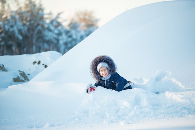 Alegre menina feliz joga no inverno nevascas