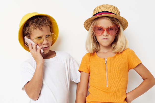 Alegre menino e menina em óculos da moda chapéus selfie posando