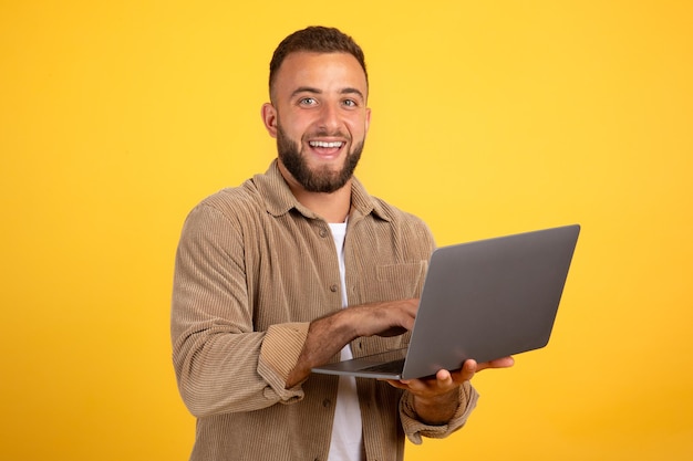 Alegre millennial hombre caucásico gerente escribiendo en la computadora portátil para el trabajo conversación de negocios