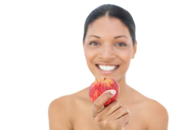 Alegre modelo de pelo negro con manzana roja