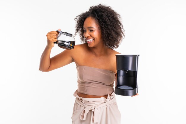 Alegre mujer africana en ropa de verano con cafetera, imagen aislada sobre fondo blanco.