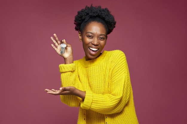 Alegre mujer afroamericana emocionada mantenga la llave de la casa en la mano comprando un apartamento moderno mujer negra ganar