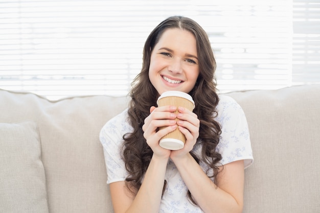 Alegre mujer bonita en pijama con café