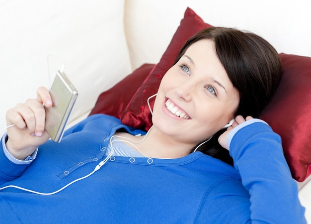 Alegre mujer escuchando música con auriculares