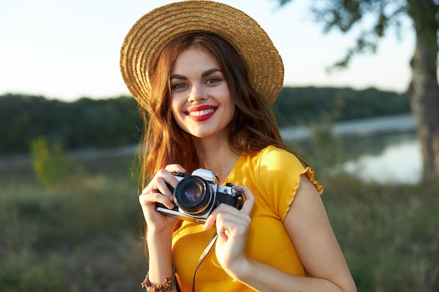 Alegre mujer fotógrafa en sombrero ocio hobby naturaleza