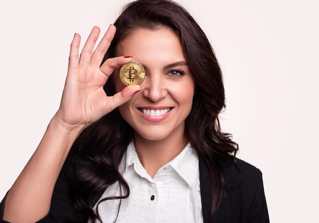 Alegre mujer de mediana edad mostrando bitcoin