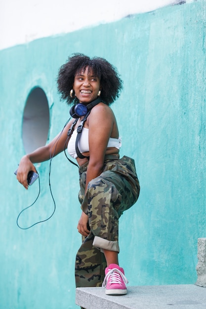 Alegre mujer negra con actitud positiva usando tecnología