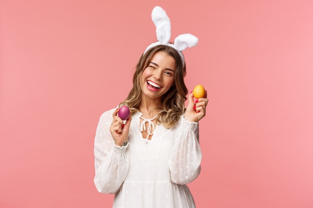 Alegre mujer rubia guapa celebrando el día de Pascua en orejas de conejo