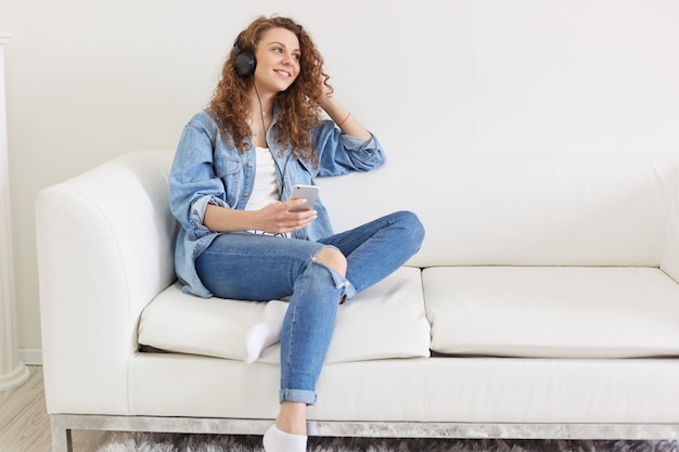 Alegre mulher alegre sentada no sofá