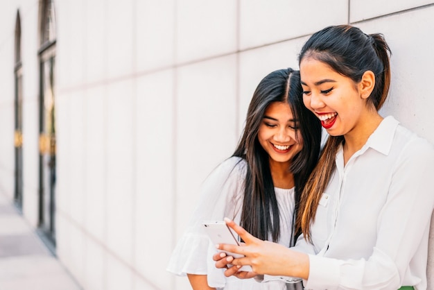 Alegre mulher asiática usando smartphone