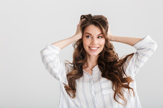 alegre mulher caucasiana sorrindo e segurando a cabeça dela isolada sobre um fundo branco