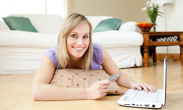 Alegre mulher compras on-line, deitado no chão