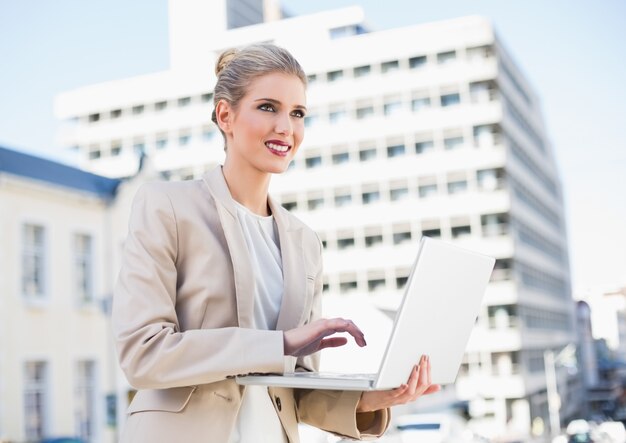 Alegre mulher de negócios linda trabalhando no laptop