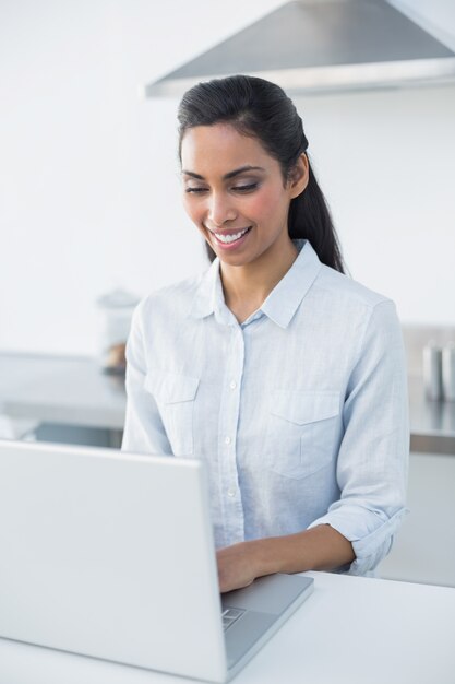 Alegre, mulher, digitando, ligado, dela, laptop, ficar, em, luminoso, cozinha