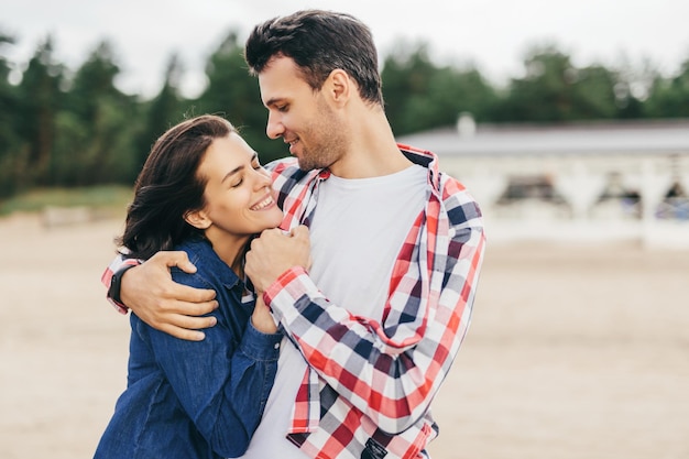 Alegre mulher e homem abraçam