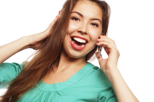 Alegre mulher falando ao telefone isolado em um backgrou branco