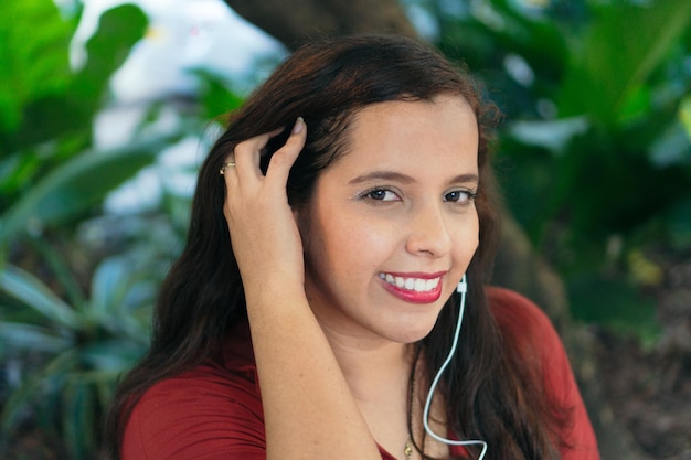 Alegre mulher hispânica olhando para a câmera em um parque