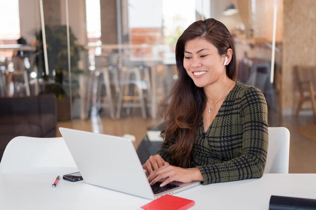 Alegre mulher jovem trabalhando no laptop