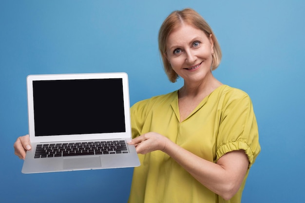 Alegre mulher madura de negócios dominando a técnica de laptop para profissão remota