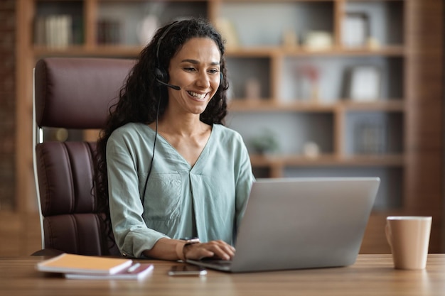 Foto alegre mulher morena tendo entrevista de emprego online em casa