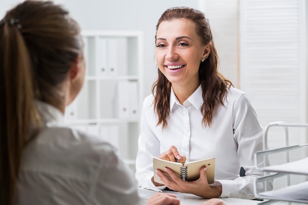 Alegre mulher tomando notas em seu escritório