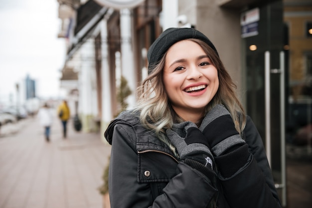 Alegre mulher usando chapéu andando na rua