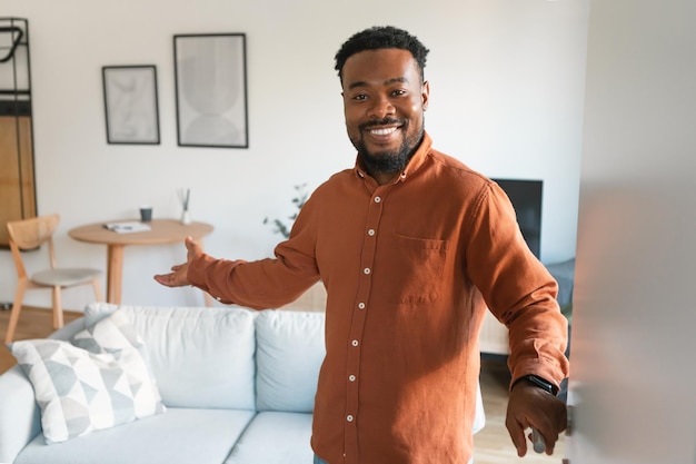 Alegre negro abrindo a porta em casa