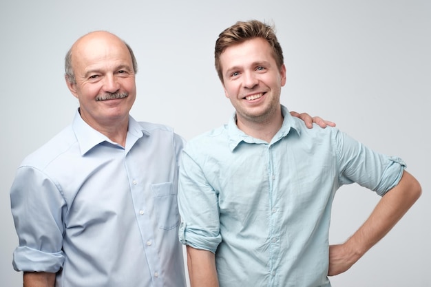 Alegre padre e hijo abrazándose y posando juntos