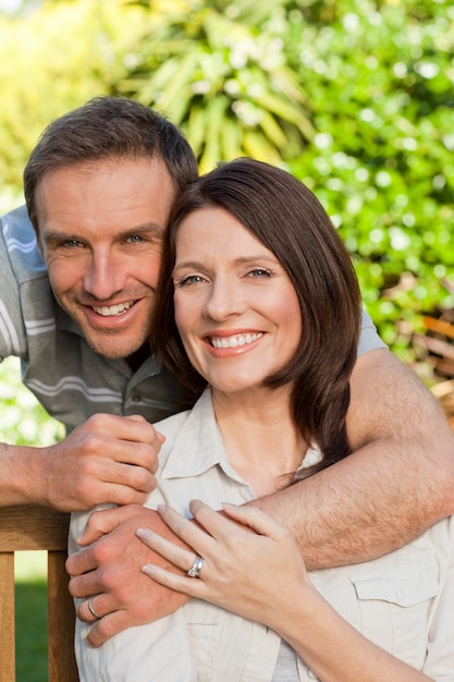 Alegre pareja abrazándose en el jardín