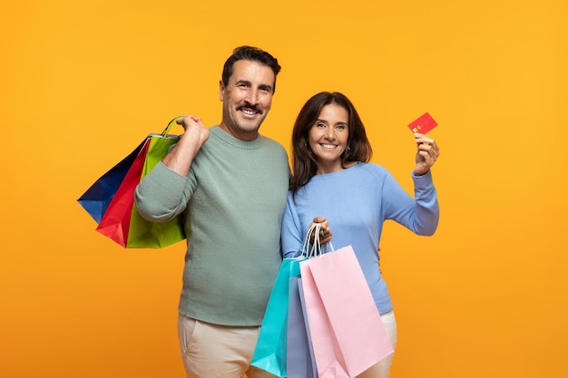 Una alegre pareja europea mayor con muchas bolsas con compras disfruta de las compras