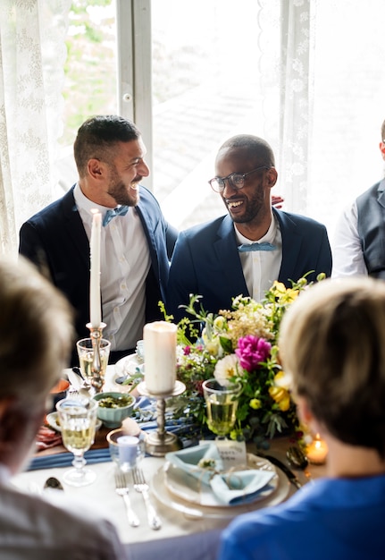 Alegre pareja gay en recepción nupcial