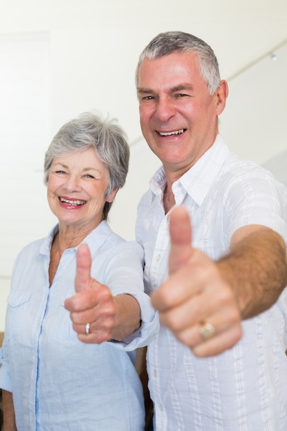 Foto alegre pareja de jubilados mirando a la cámara dando pulgares