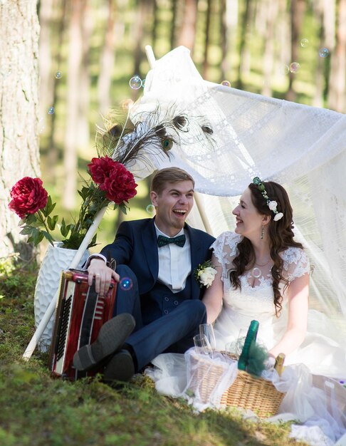 Foto una alegre pareja de recién casados sentados en el parque