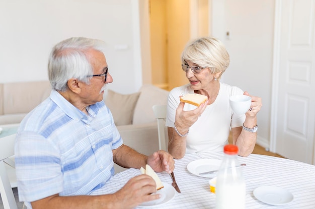 Foto alegre pareja senior desayunando en casa