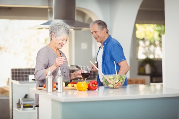 Alegre pareja senior preparando una ensalada