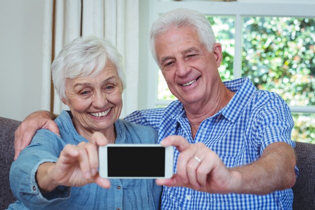 Alegre pareja senior tomando selfie