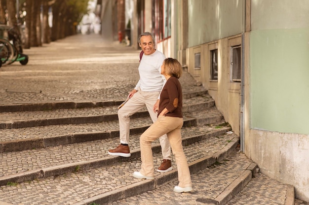 Alegre pareja de viajeros maduros caminando por las encantadoras calles de lisboa