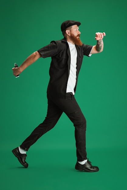 Alegre. Retrato de hombre hermoso caucásico aislado en verde