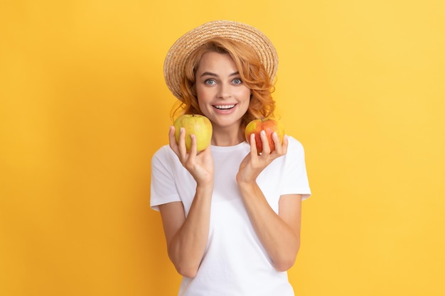 Alegre ruiva de chapéu de palha segura vitamina de maçã