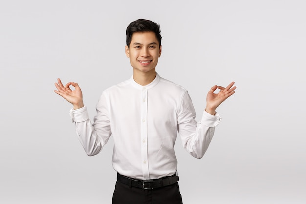 Alegre sorridente jovem empresário asiático com camisa branca, aliviada