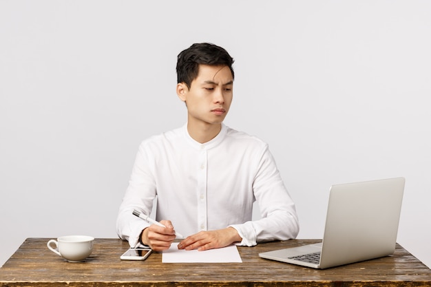 Alegre sorridente jovem empresário asiático no escritório