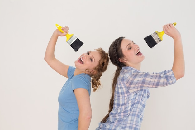 Alegres amigas cantando en pinceles