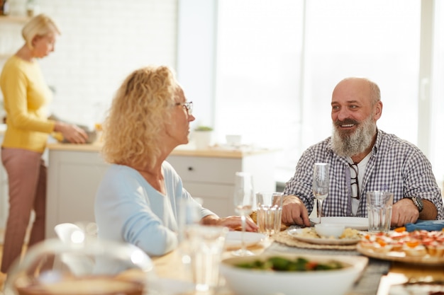 Alegres amigos hablando mientras esperan la cena